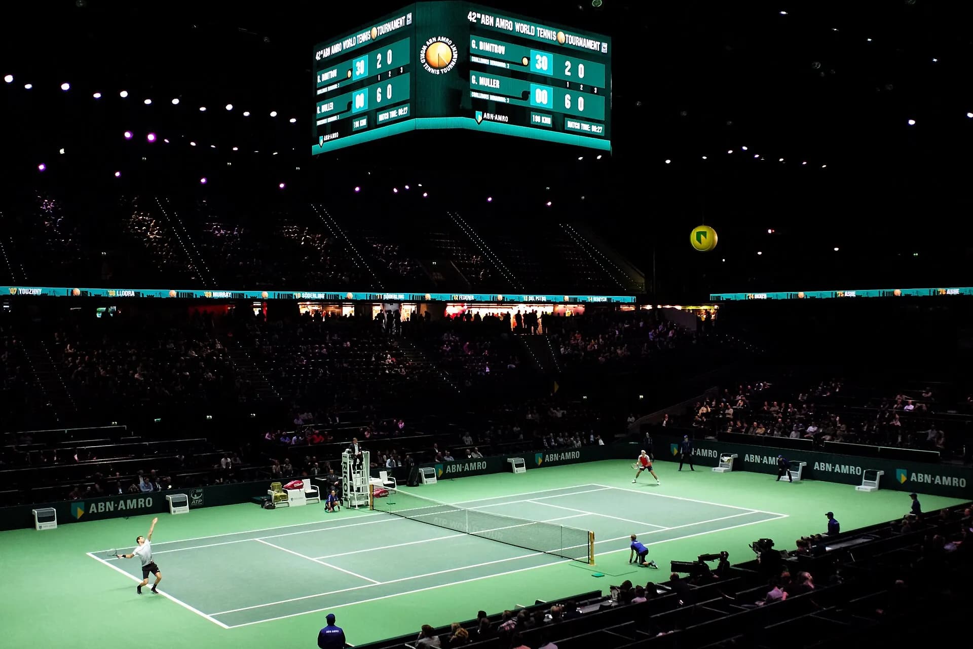 Match sur le court central sous le tableau d’affichage, vu depuis les tribunes